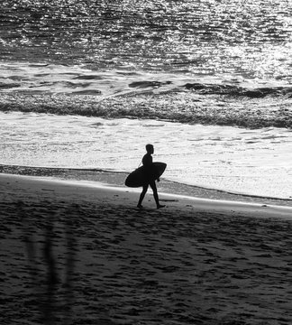 Surfist walking at the beach waiting for a good wave