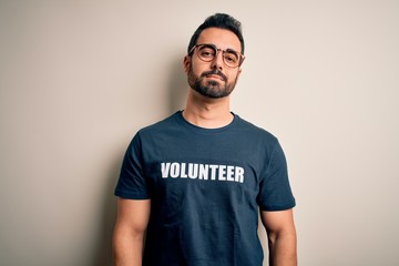 Handsome man with beard wearing t-shirt with volunteer message over white background looking sleepy and tired, exhausted for fatigue and hangover, lazy eyes in the morning.