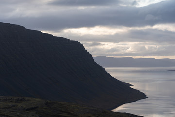Fototapeta premium Fjord illuminated by sunset in Westfjords Iceland