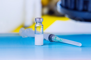 vial with medicine and syringe on laboratory bench