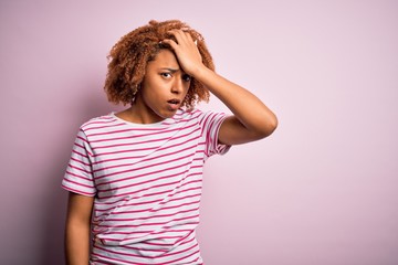 Young beautiful African American afro woman with curly hair wearing casual striped t-shirt...