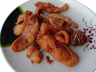 Fried bananas pile on plate isolated on white background closeup. Thailand dessert food snack. In Samut Sakhon, Thailand.