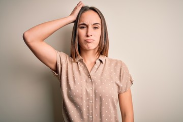 Obraz premium Young beautiful woman wearing casual shirt standing over isolated white background confuse and wonder about question. Uncertain with doubt, thinking with hand on head. Pensive concept.