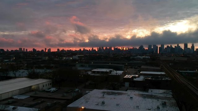 drone footage of an urban community near downtown Chicago during sunset over by the CTA Train stop. a complete view of the Chicago skyline and orange red clouds
