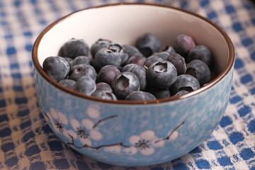 Close up of many fresh blue berry in a bowl .