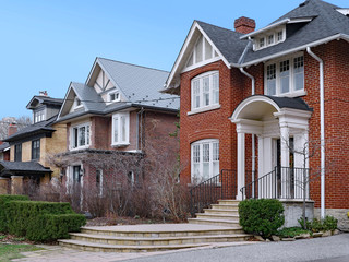 Residential street with  detached two story houses with gables