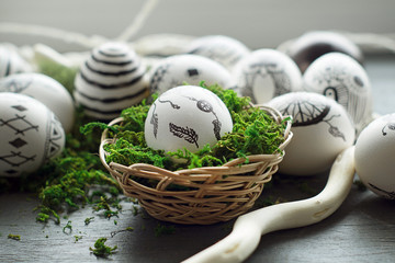 Easter eggs with traditional Indian patterns in a nest of wood shavings and moss. A mixture of cultures.