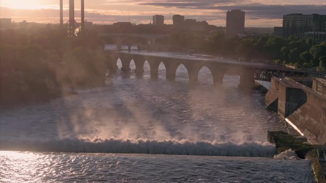 Aerial: Rapids on the Mississippi River in downtown Minneapolis at sunrise. In the background is Stone Arch Bridge. Minneapolis, Minnesota, USA. 