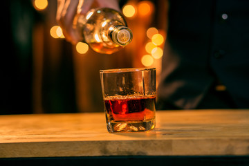 Barman pouring whiskey whiskey glass