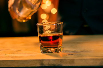 Barman pouring whiskey whiskey glass