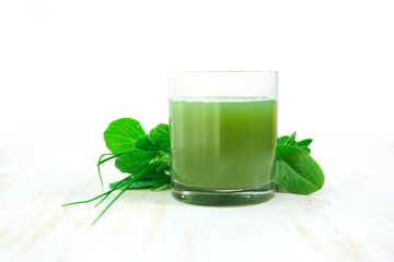 green vegetable juice in a glass on a wooden table. healthy drink