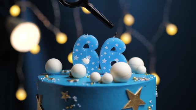 Birthday cake number 66 stars sky and moon concept, blue candle is fire by lighter and then blows out. Copy space on right side of screen if required. Close-up and slow motion