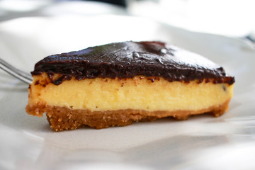 A slice of chocolate cheese cake on a white plate.