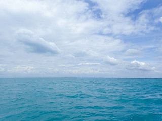 Fototapeta na wymiar Puffy cloud on the blue sky and rough wave on the ocean