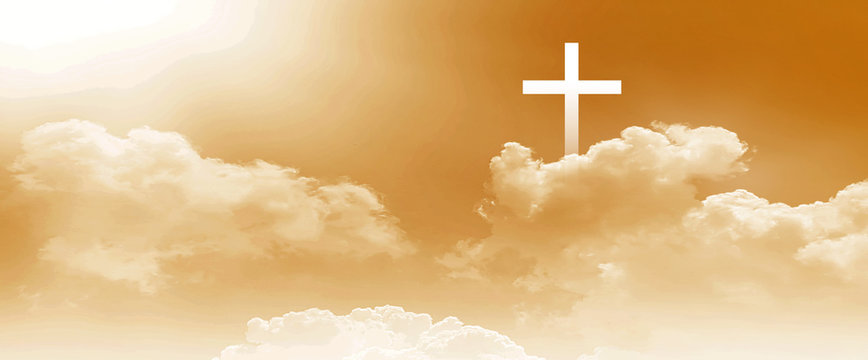 The Christian cross looks bright in the golden sky, with soft white clouds and a beautiful background light that leads to peace and heaven.