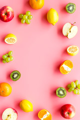 Colorful fruit mockup. Cut apple, kiwi, citrus on pink background top-down copy space