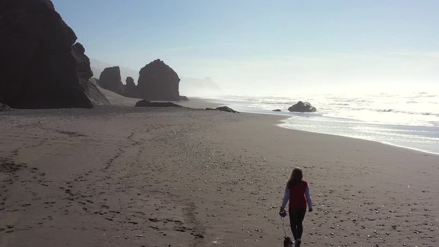 woman out walking the beach looking for treasures and polished rocks and the ever popular agate in Gold Beach Oregon