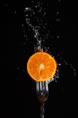 Fototapeta na wymiar orange in water on a fork