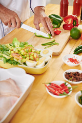 Man cutting green bell pepper for delicious healthy salad