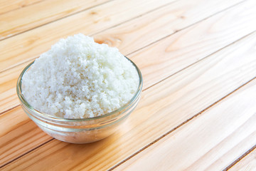 Sea salt in bowl on wooden background, Sea salt is salt that is produced by the evaporation of seawater. Used as a seasoning in foods, cooking, cosmetics and for preserving food..