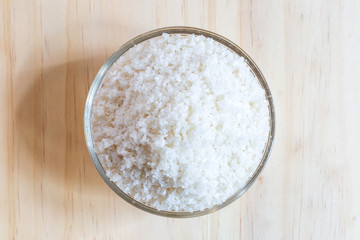 Sea salt in bowl on wooden background, Sea salt is salt that is produced by the evaporation of seawater. Used as a seasoning in foods, cooking, cosmetics and for preserving food..