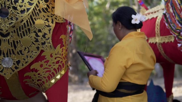 Woman looking at photo of a dead family member in a traditional Balinese funeral ceremony. Last goodbye before cremation.