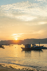 Fototapeta na wymiar sunset with boat over the sea cat tien vietnam