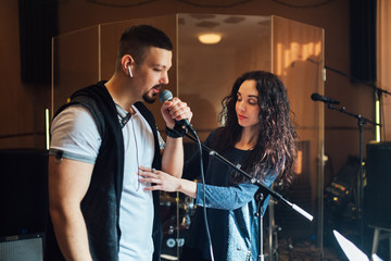 Woman coaching a male vocalist or singer