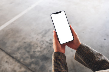 Top view mockup image of a woman holding mobile phone with blank white screen on the street