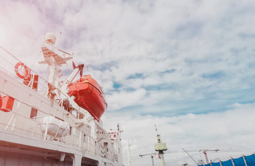 Rescue boat or lifeboat of Cargo ship moored alongside in shipyard and the boat on mounting bracket.