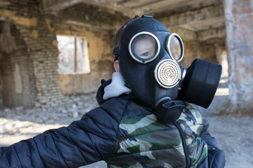 child in a gas mask in a destroyed building.