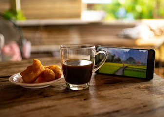 Black coffee and watching news from smartphone.