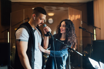 Woman coaching a male vocalist or singer