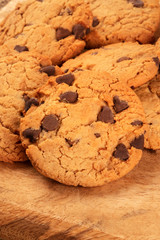 Chocolate chip cookies close-up on a rustic wooden background with a place for logo or text
