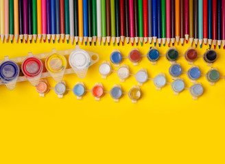 Overhead shot of stationery on yellow paper. Frame of school supplies
