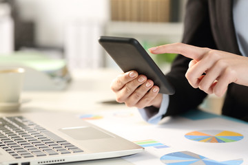 Business woman hands checking phone at the office