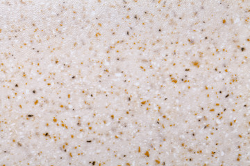 Grainy beige background with yellow and white spots. Texture backdrop with small crumb pattern.