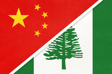 China or PRC vs Norfolk Island national flag from textile. Relationship between Asian and Oceania countries.