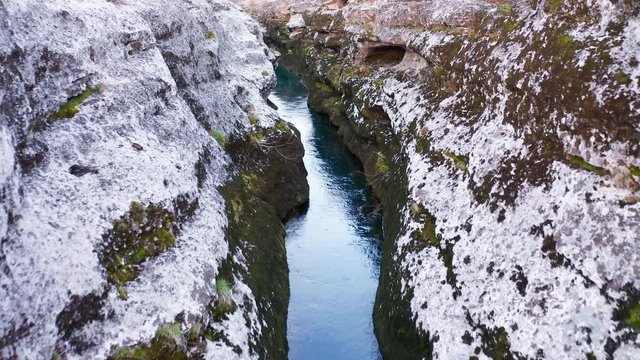 Narrow mountain river flowing through desolate rocky landscape. Stream bed cut deep into stones. Upstream of Cijevna (Cem) in Montenegro. Aerial footage.
