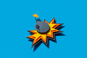 Handmade colorful paper cutting bomb. Pop art and comic style. On blue background. Cartoon and flat. 