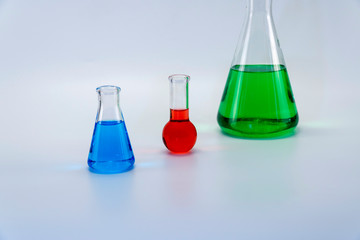 Laboratory glassware with liquid on white background. glass chemical flask with reagent.
