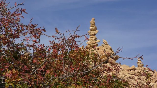 Pyramid of stones on top of a hill against the blue sky.