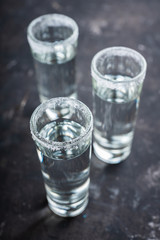 Tequila shots on the dark rustic background. Selective focus. Shallow depth of field.