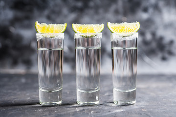 Tequila shots on the dark rustic background. Selective focus. Shallow depth of field.