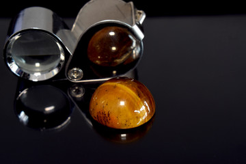 
tiger eye
Is a yellow gem Rare, expensive Laying on the glass floor with reflection