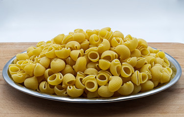Pipe rigate pasta. Italian raw pasta, lined pipe on wooden table.