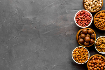 Set of macadamia, hazelnut, walnut, almond, pistachio, pecans nuts on grey background top-down...