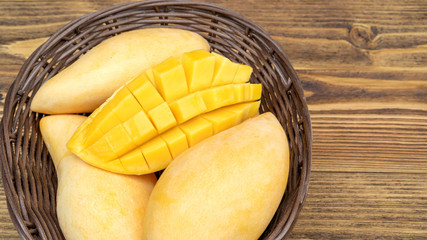 Ripe Barracuda mango on a wooden table.