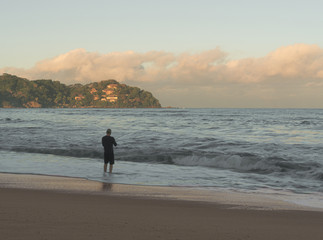 Naklejka premium Fisher man Fishing with Spinning Rod in Mexican Beach.