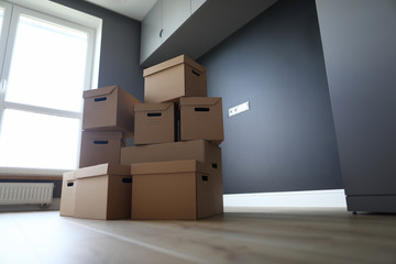 Lot of cardboard boxes on wooden floor new flat closeup background. Fast banking credit concept